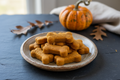 Pumpkin bone-shaped dog treats on a plate, natural pet snacks from Bayou Chien Raw Foods